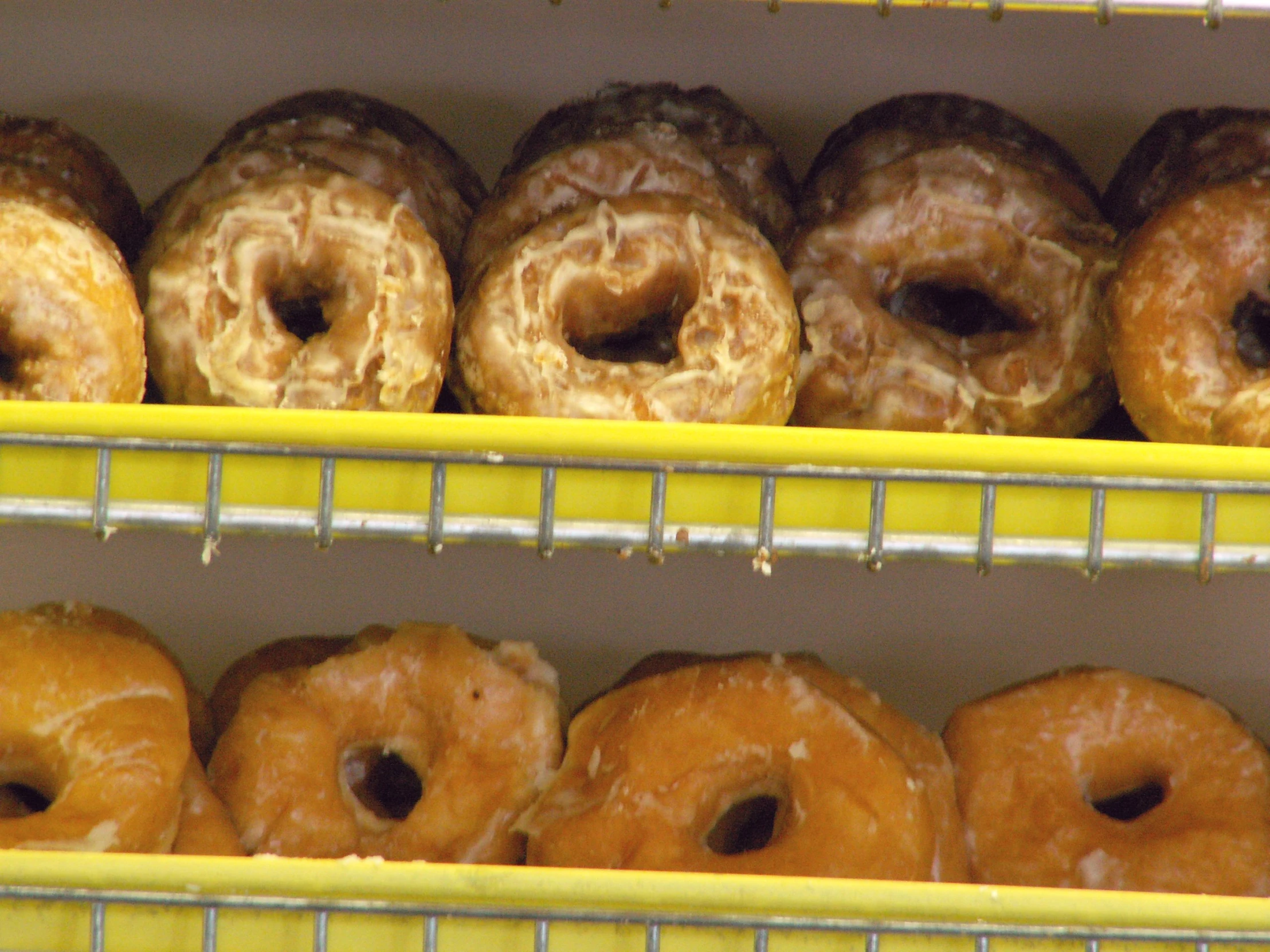 shelves with donuts and doughnut holes inside of a bakery