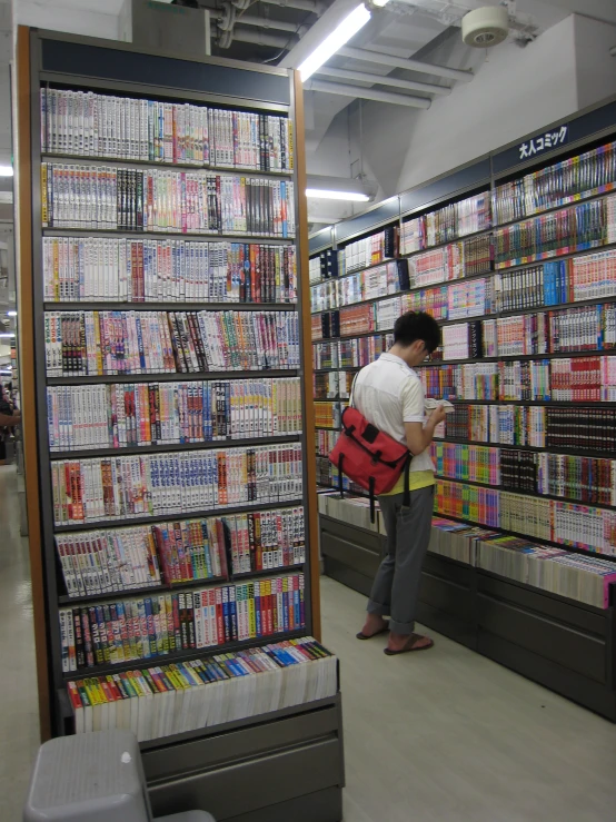 a man in white shirt looking at video game shelves