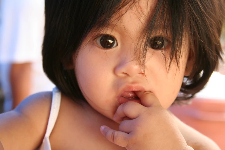  holding finger to mouth while laying on a bed