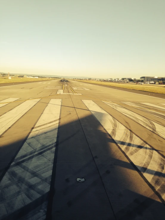 the shadow of a person is cast in an airplane's tarmac
