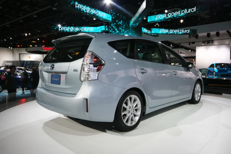 a small white toyota hybrid vehicle sitting on display