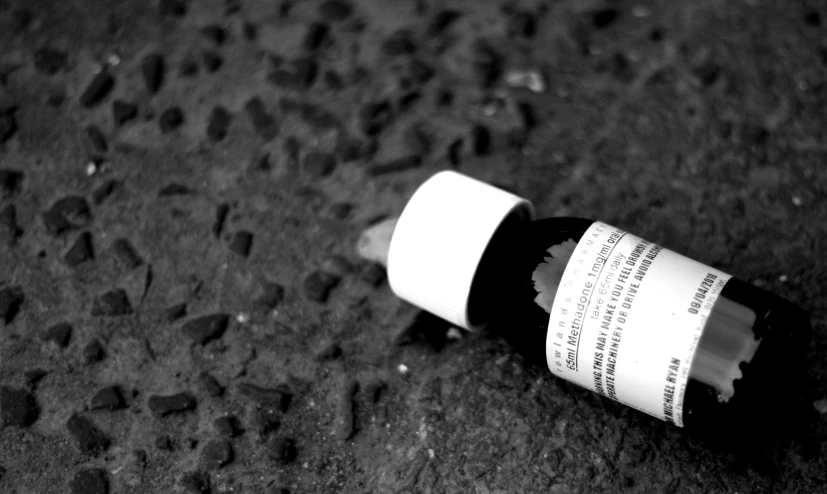 a white and brown bottle sitting on the ground