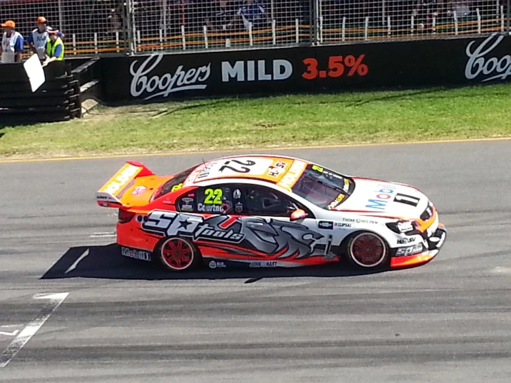 a car turning on a track with a person holding the door open