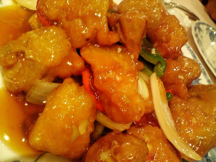 a plate of chinese food covered with sauce
