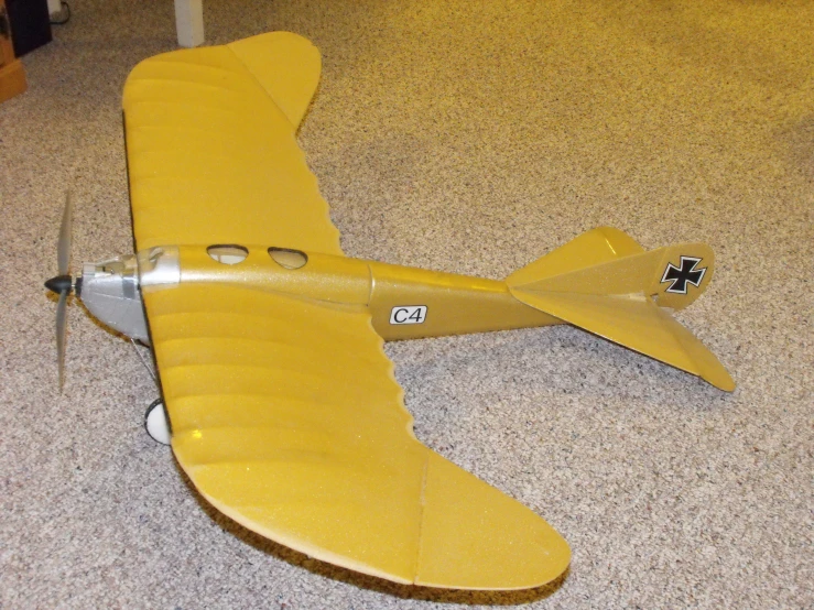 an antique plane with a propeller lying on the ground