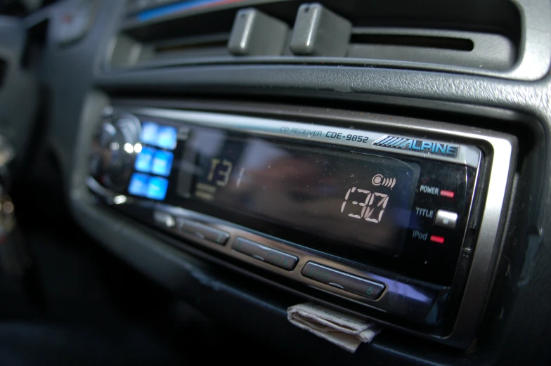 an electronic clock mounted to the dashboard of a car