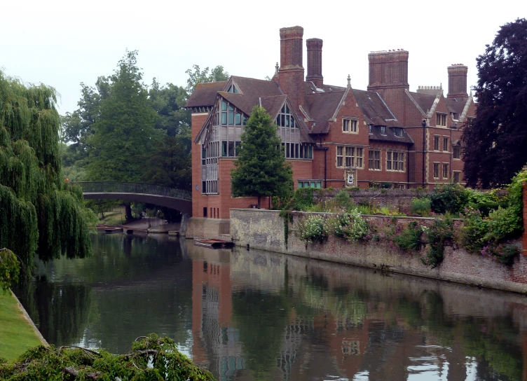 a large building with trees next to it next to water