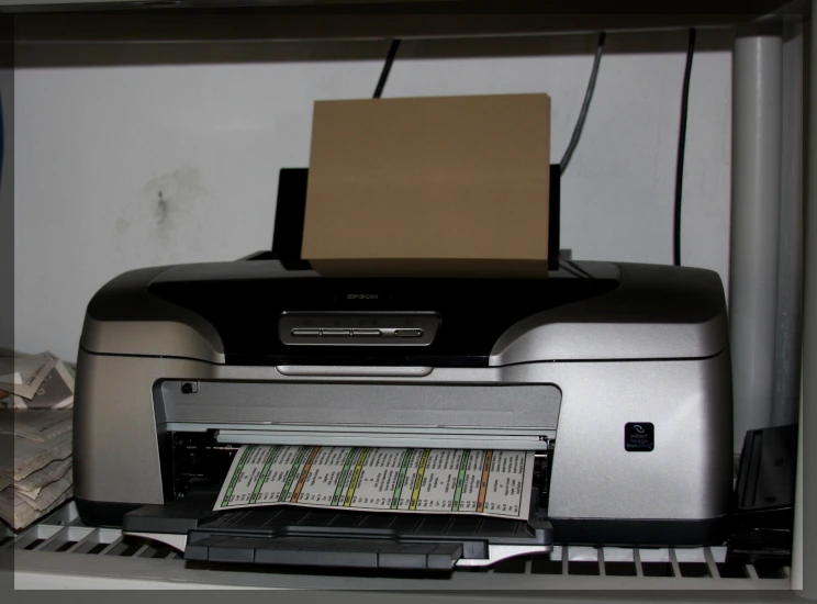 a po printer on a shelf next to some papers