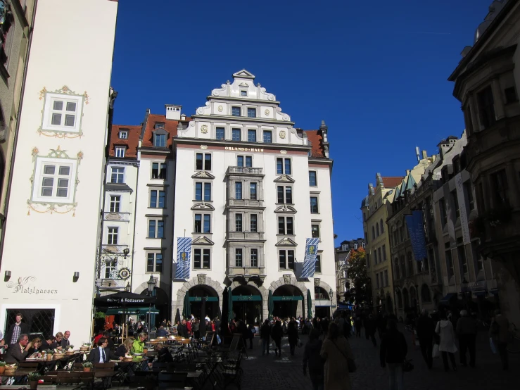 a large crowd is walking by a street with people