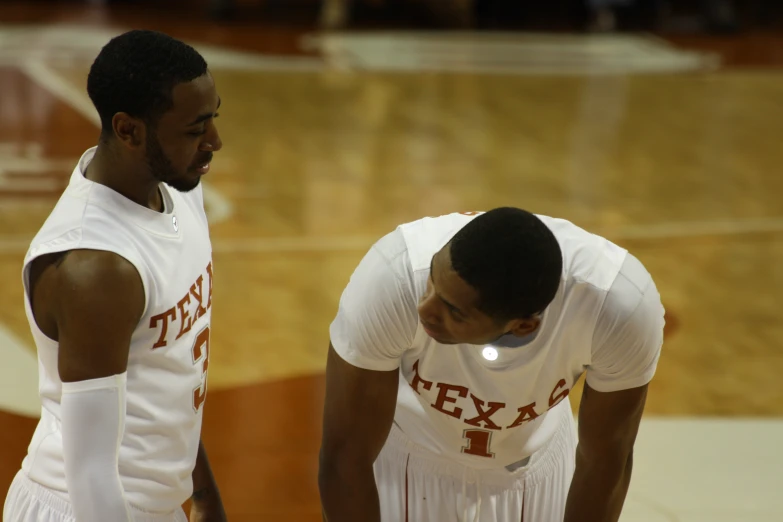 two basketball players stand next to each other on the court