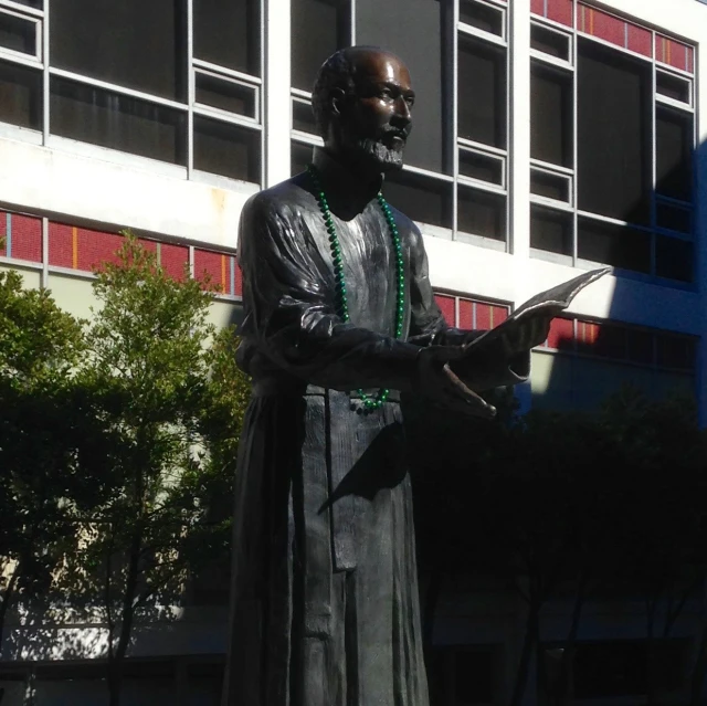 there is a statue of the priest that looks like he is holding a book