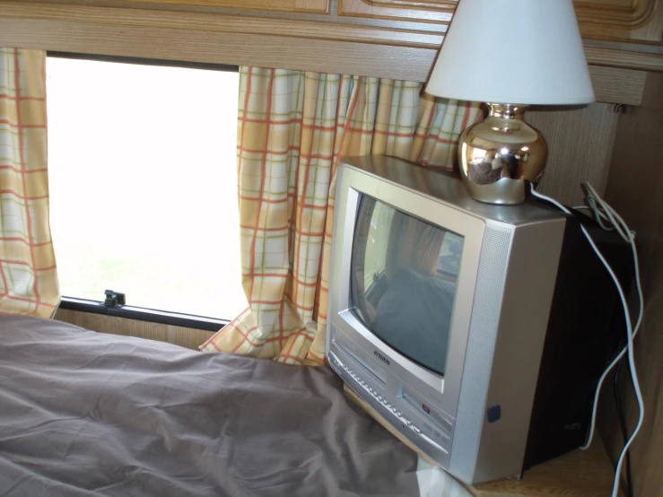 a bedroom with a television and a lamp on top