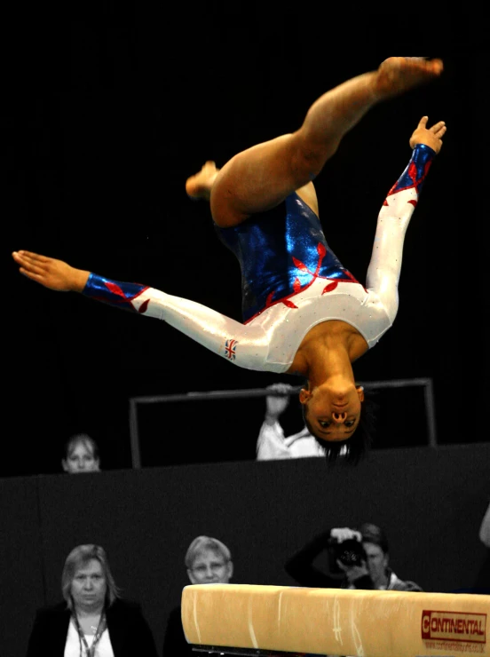 a male athlete that is on the balance beam