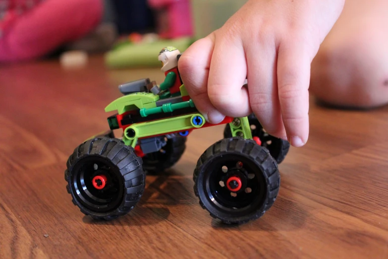 a hand with a toy truck on the table