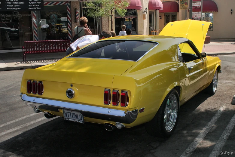 a car with the hood open parked on the street