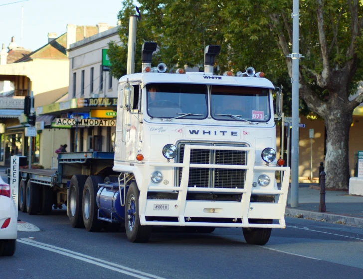 a white truck is traveling down the road