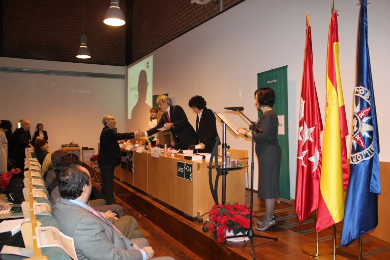 a crowd of people standing around tables with flags