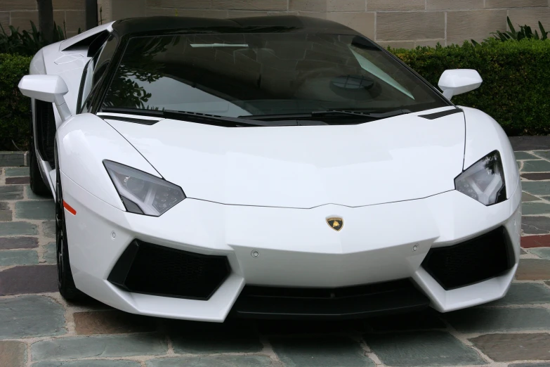 a very clean white lambong sitting in a driveway