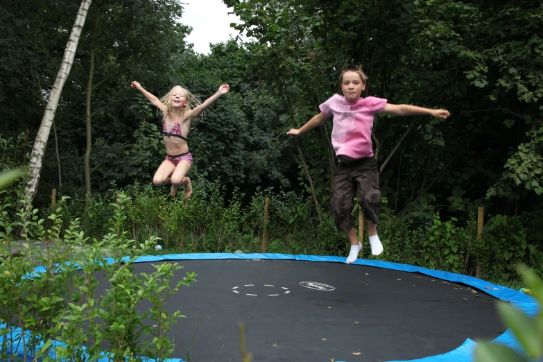 there are two children jumping on the trampoline