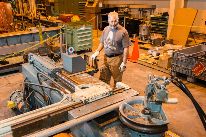 a man standing next to some machine work