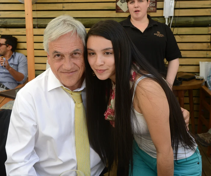 the man is standing next to a girl in a white shirt and tie