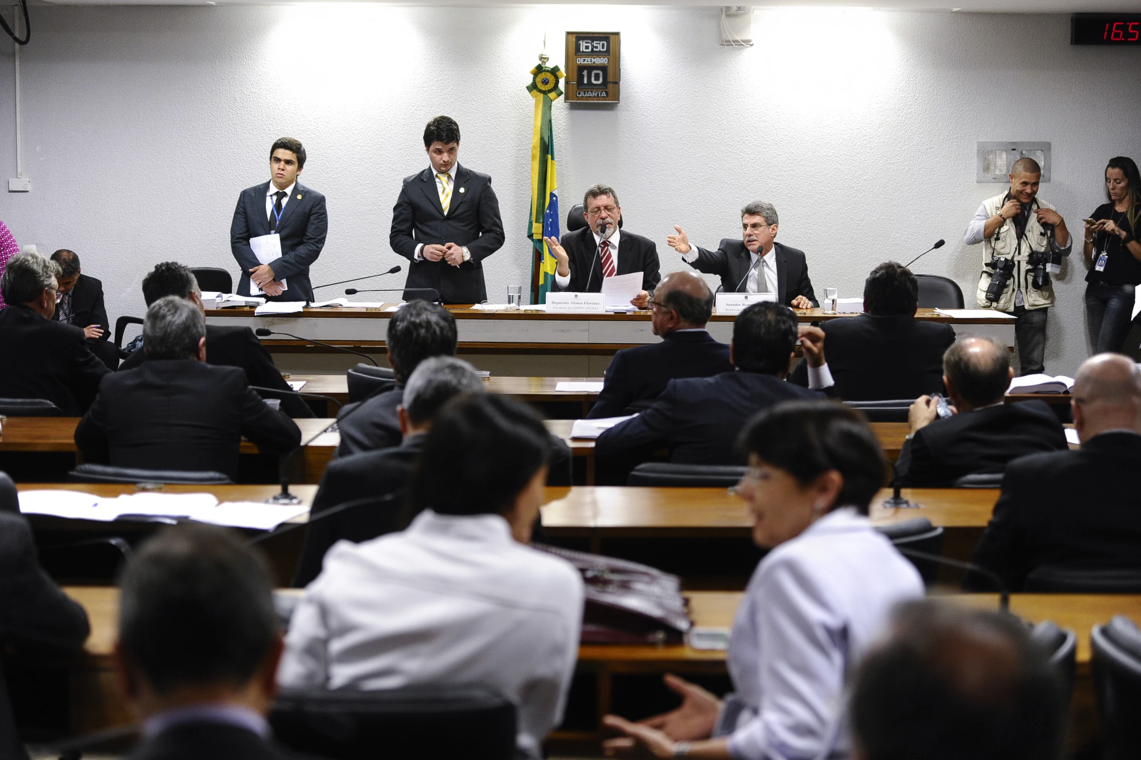 several people wearing suits sitting in front of a meeting