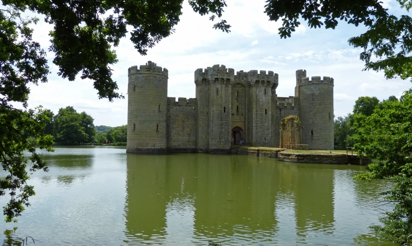 an old castle and a lake surrounded by trees