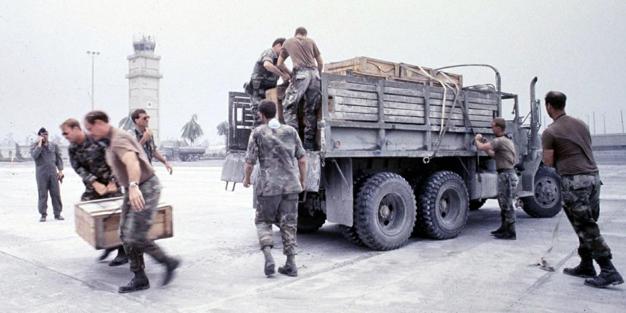 military men and civilians unloading a truck