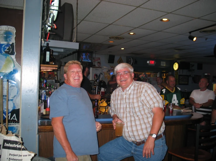 some men in jeans and t - shirts at a bar