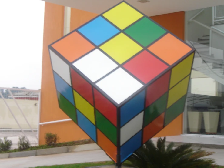 a large multi - colored rubik rubai cube is standing out in the sun
