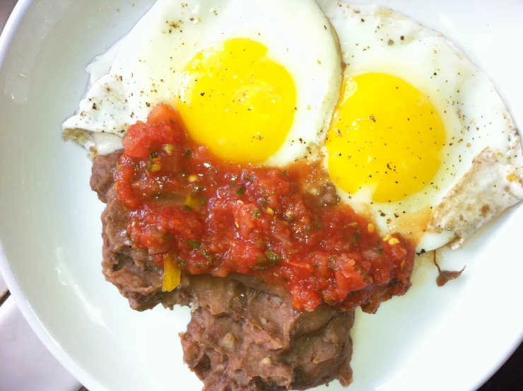 an image of eggs, meat and tomato on plate