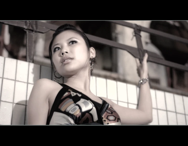 an asian woman posing for the camera in front of tiled walls