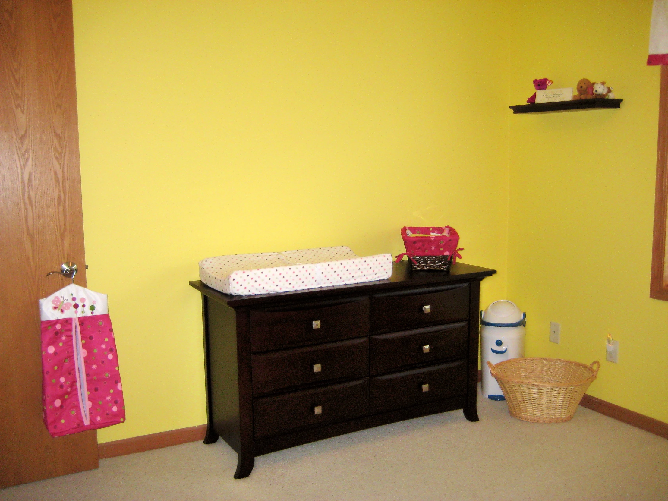 the interior of a nursery with yellow walls and black furniture