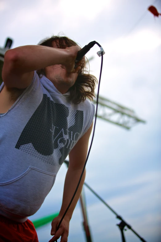 a man with long hair holding a microphone