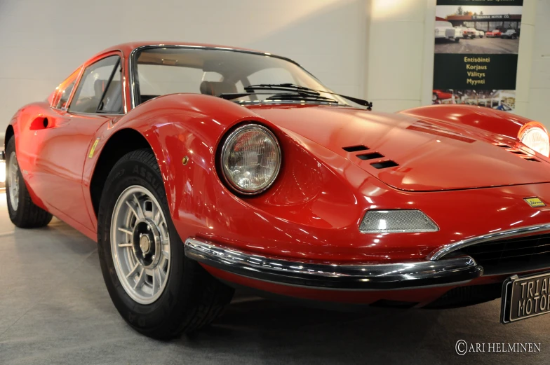 an old red sports car is parked near other vehicles