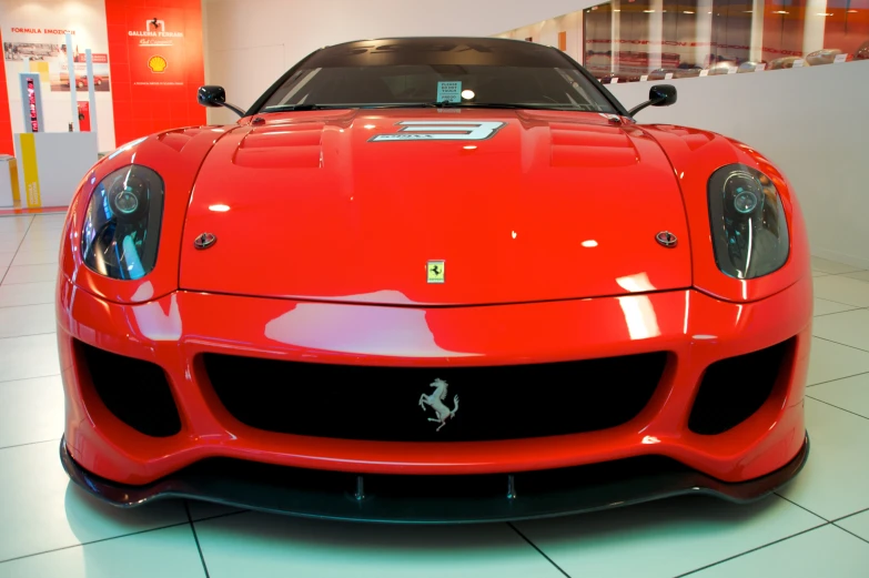 a red sports car sits in the center of the museum