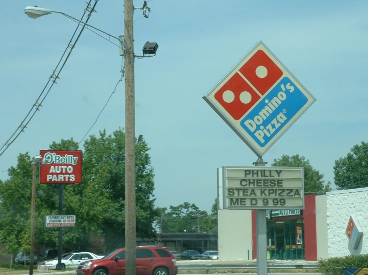 a pizza restaurant and drive in with cars parked outside