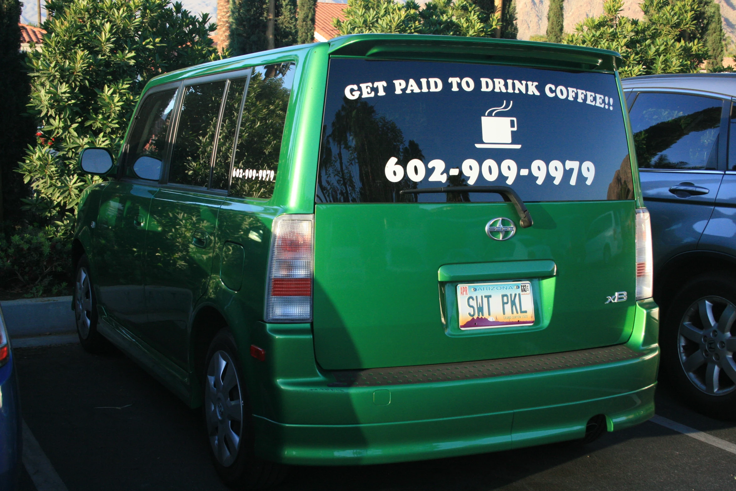 a green passenger van parked in a parking lot