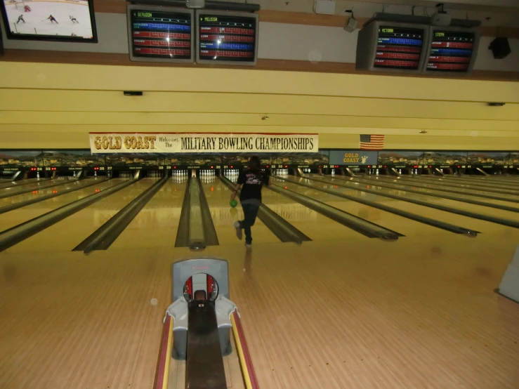 two people walking down a bowling alley during a game