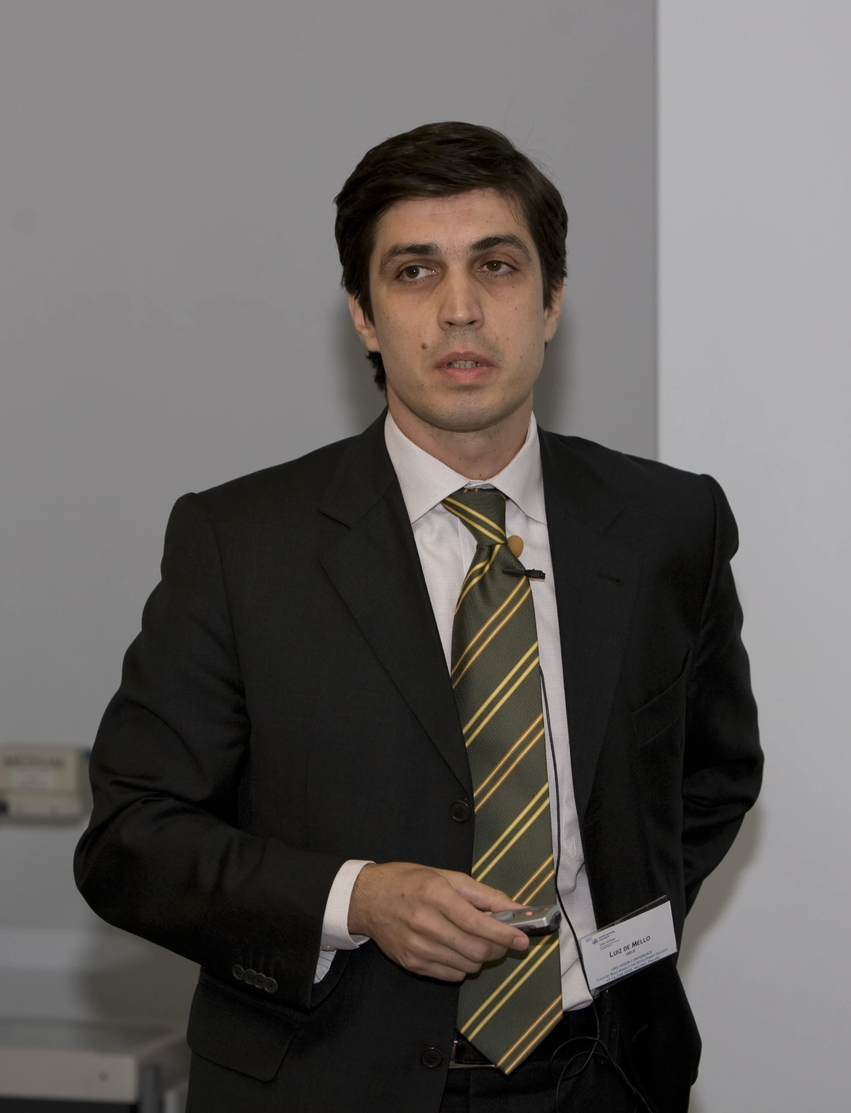 man in suit and tie standing with hand on hip