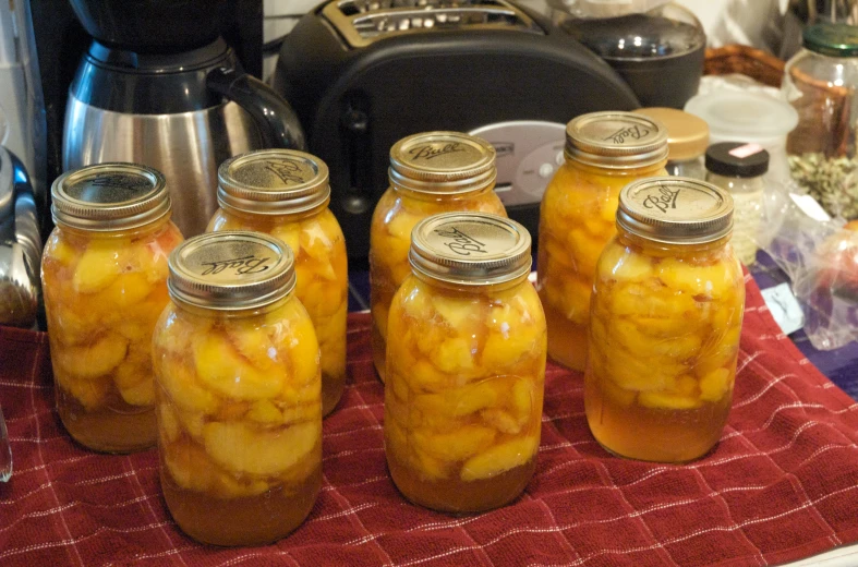 several jars filled with pickles on a towel