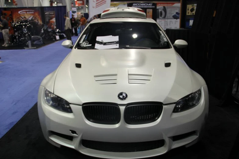 a white car on display at an automobile show