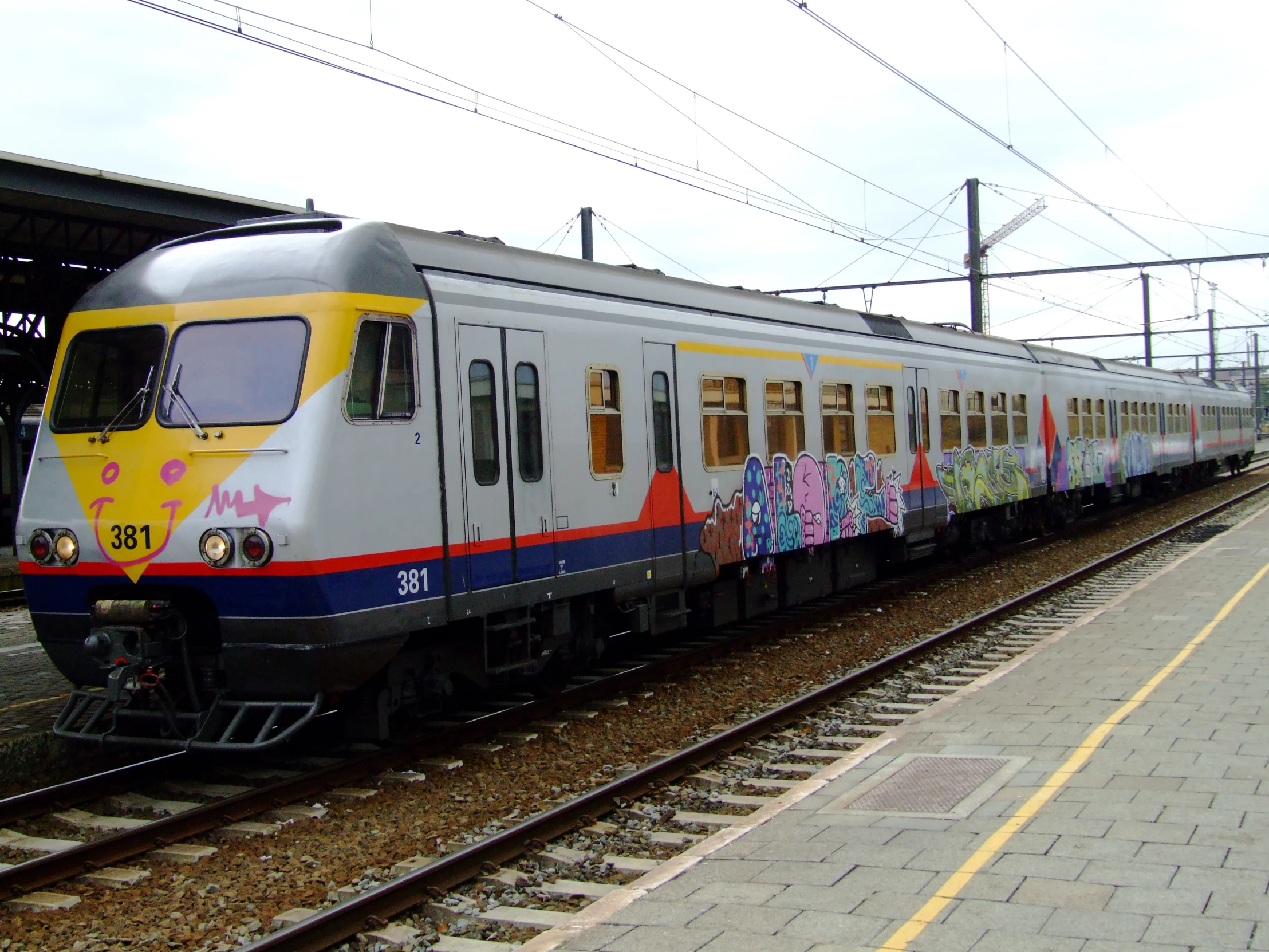 a passenger train with a number of graffiti on it