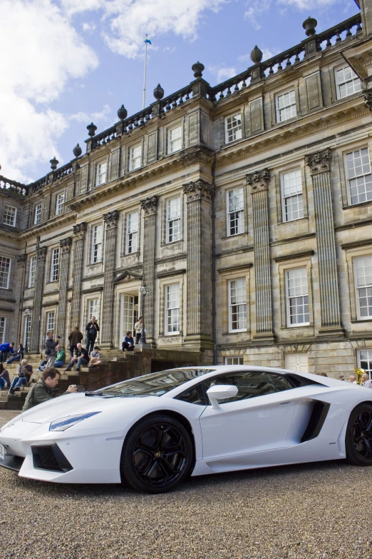a very white sports car in front of a large building