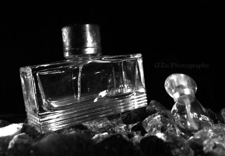 a bottle of perfume on rocks in the dark