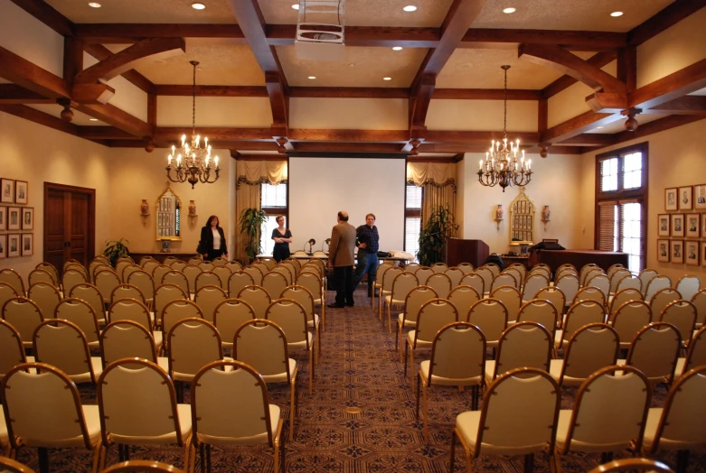 several people are in a conference room full of chairs