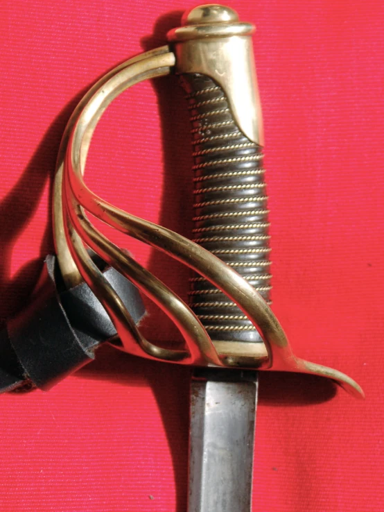 a gold plated sword with metal accents on the end