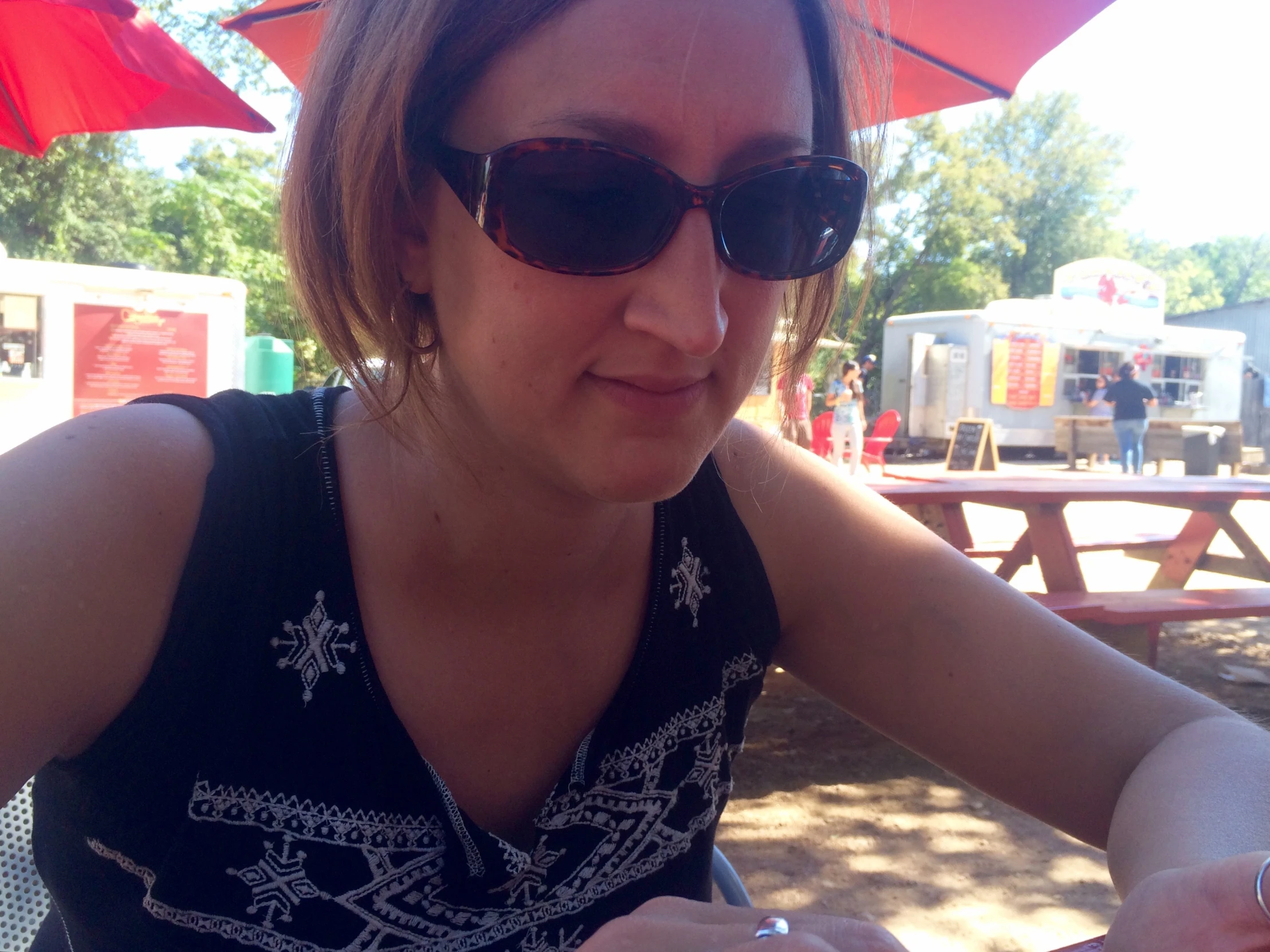 a woman wearing sunglasses sitting in a bench