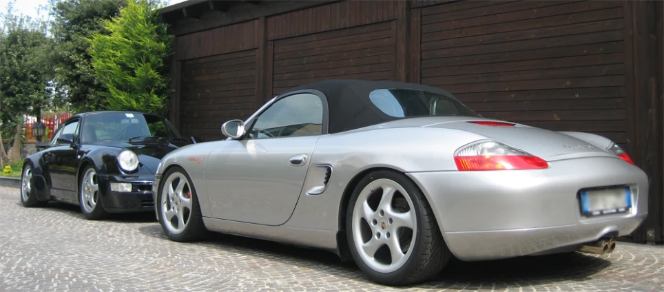 silver sports cars are parked in front of a garage