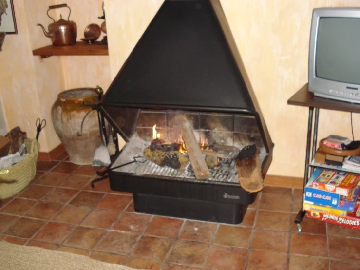 a room with a fireplace and a television on the table